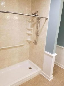 Walk-in shower with a white base and beige walls.
