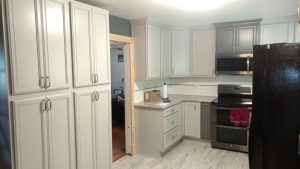 A kitchen with white cabinets and granite countertops.